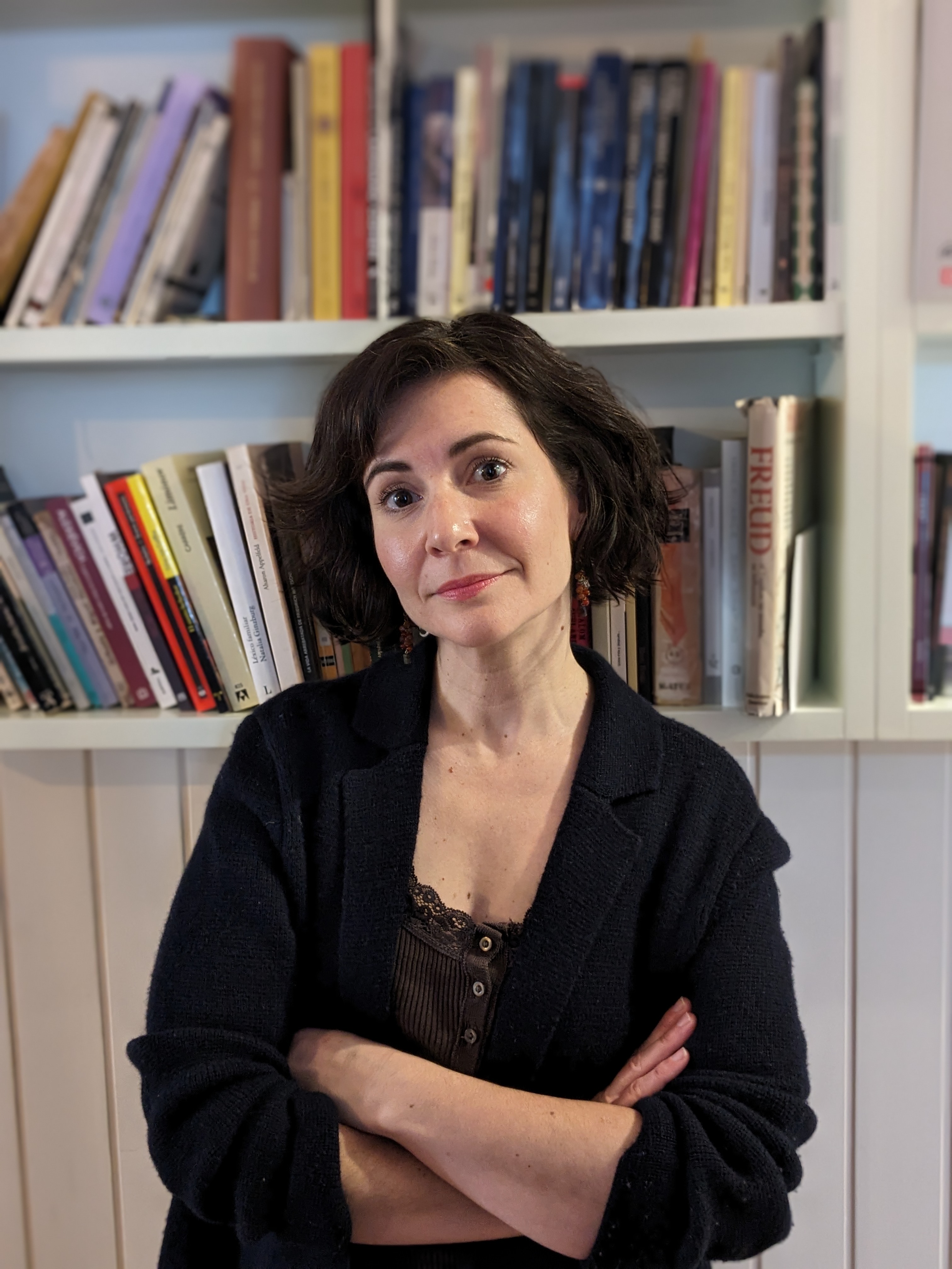 Dr Angy Cohen standing in front of bookshelves.