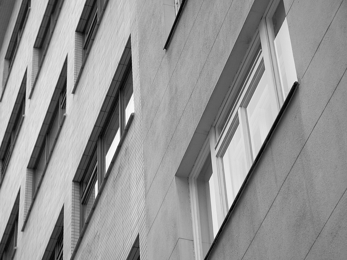 Black and white photo loooking up at a residential building. Source: Martin Kopta, Wikimedia Commons, Creative Commons Attribution 3.0.