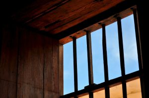 A picture of windows with metal bars. Credit: Juan Pablo Jou Valencia via Unsplash